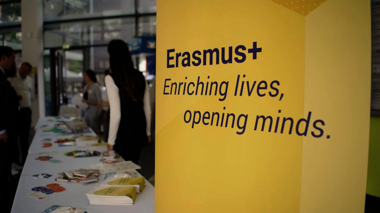 Anmeldung bei der Erasmus+ Jahrestagung 2023 an der OVGU Magdeburg mit Erasmus+ Roll-Up im Vordergrund rechts und Kolleginnen und Kollegen der NA DAAD im Hintergrund links. 
