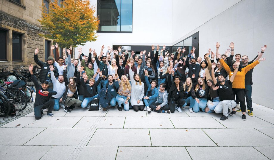 Group photo at the LEI Annual Meeting 2022 in Münster in front of a university building. Everyone is smiling cheerfully into the camera. 