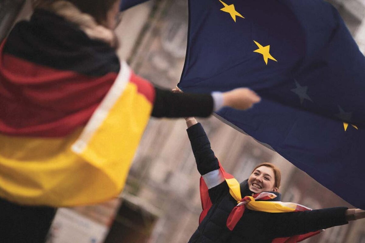 Zwei Studentinnen schwingen eine Europaflagge
