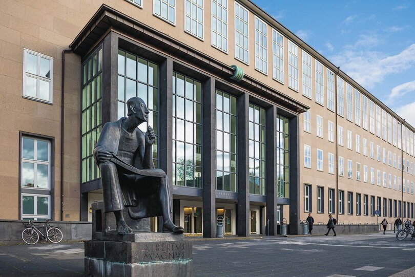  Eingangsportal der Universität Köln mit Bronzestatue Bronzestatue von Albertus Magnus im Vordergrund